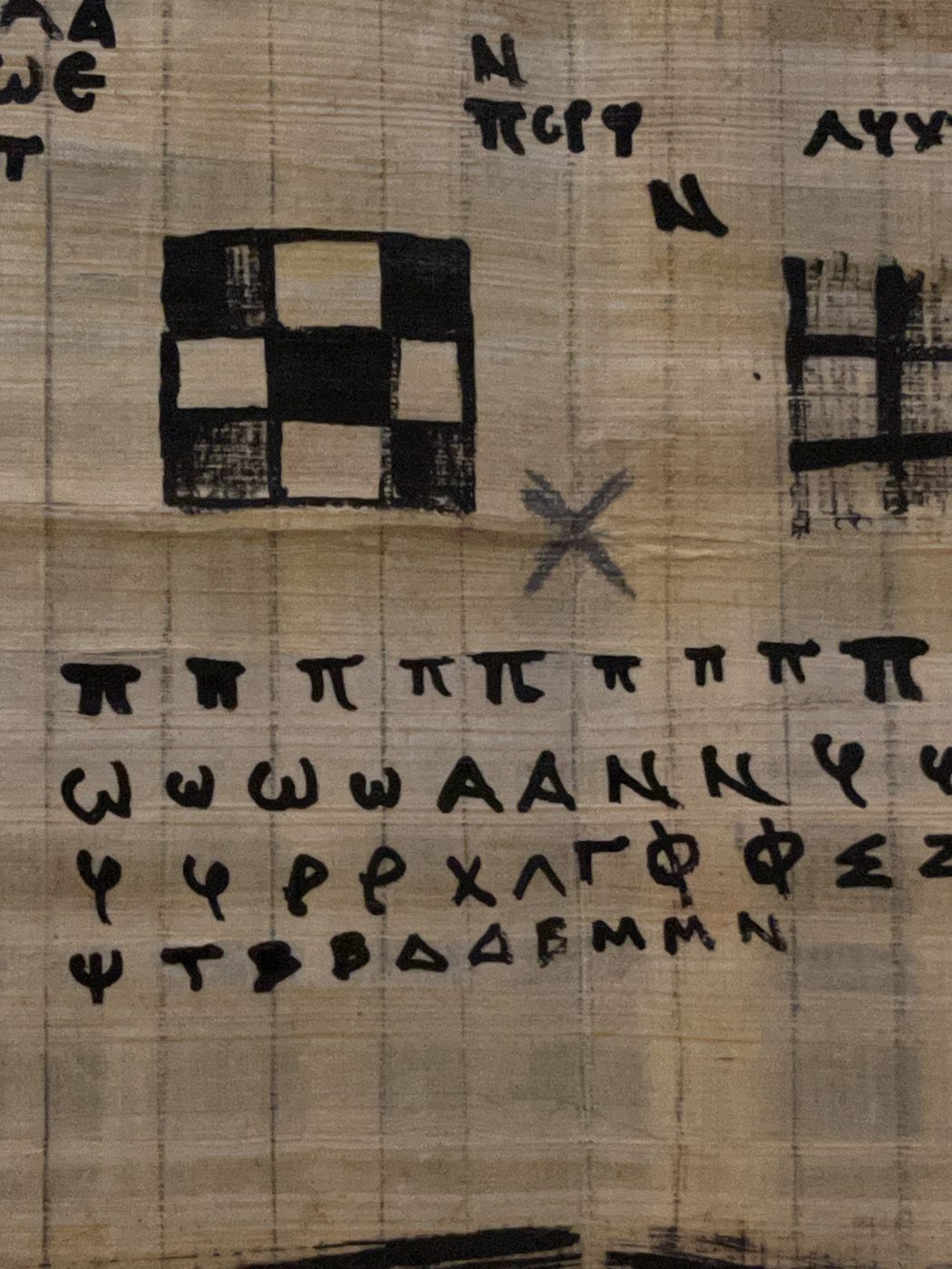 Close-up of reed-pen Greek letters and pi symbols on papyrus